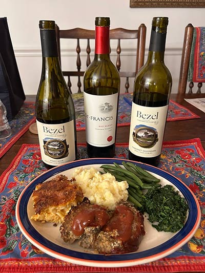 Dish of meatloaf with bottles of Bezel Cabernet Sauvignon, St. Francis Red Blend, and Bezel Pinot Noir wines from California behind the plate